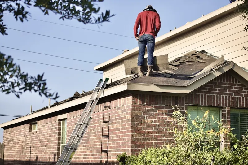 Professional roofer working on a residential roof in Talent